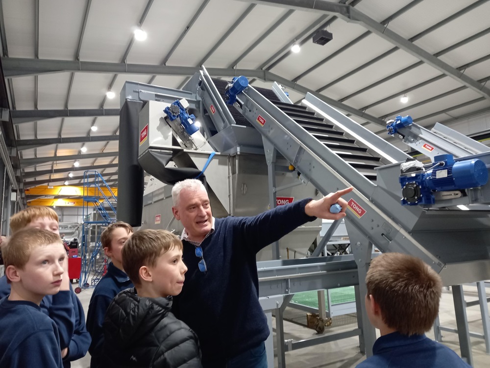 Tong staff member show pupils around the factory
