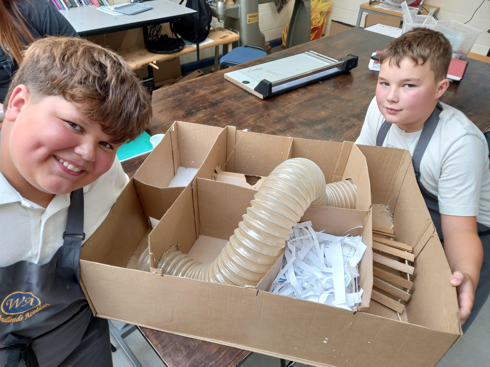 2 pupils sit proudly with their designed Gerbil House