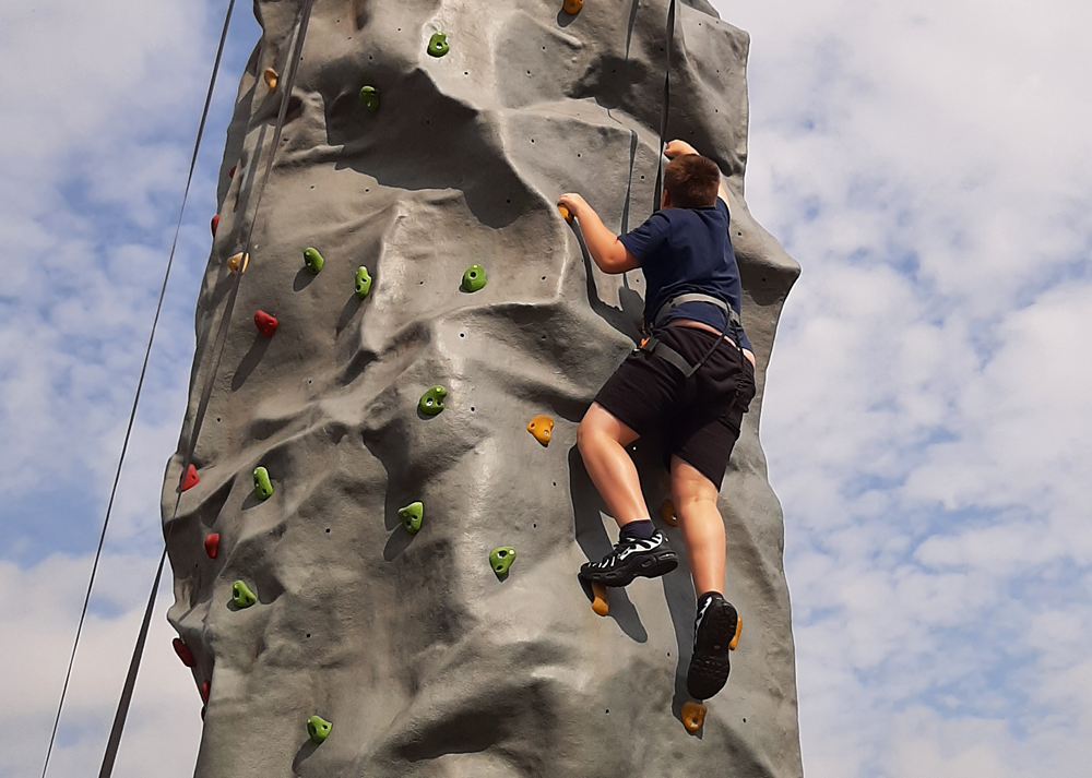 pupil climbs the wall, almost to the top